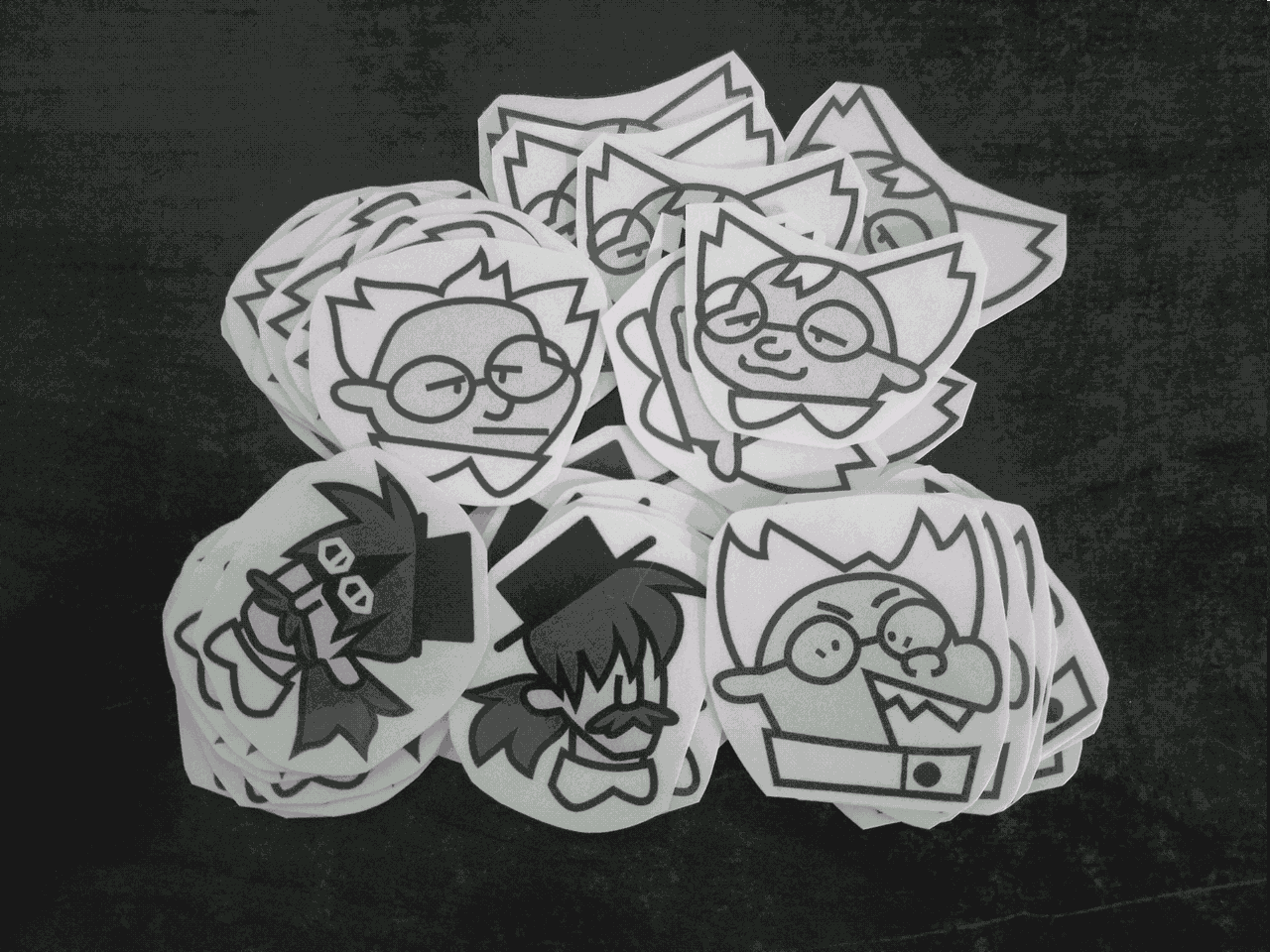 A pile of stickers of the main Needleminder characters.